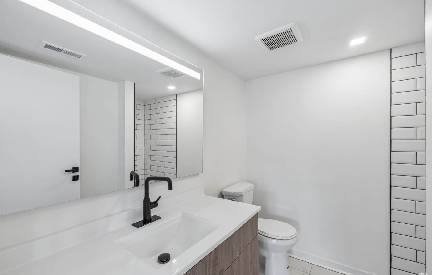 Modern bathroom vanity with black fixtures and marble-look tile