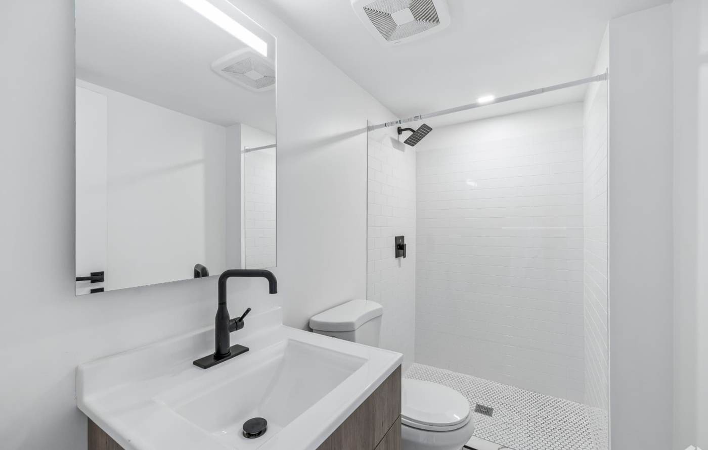 Bathroom with subway-tile walk-in shower and backlit LED mirror