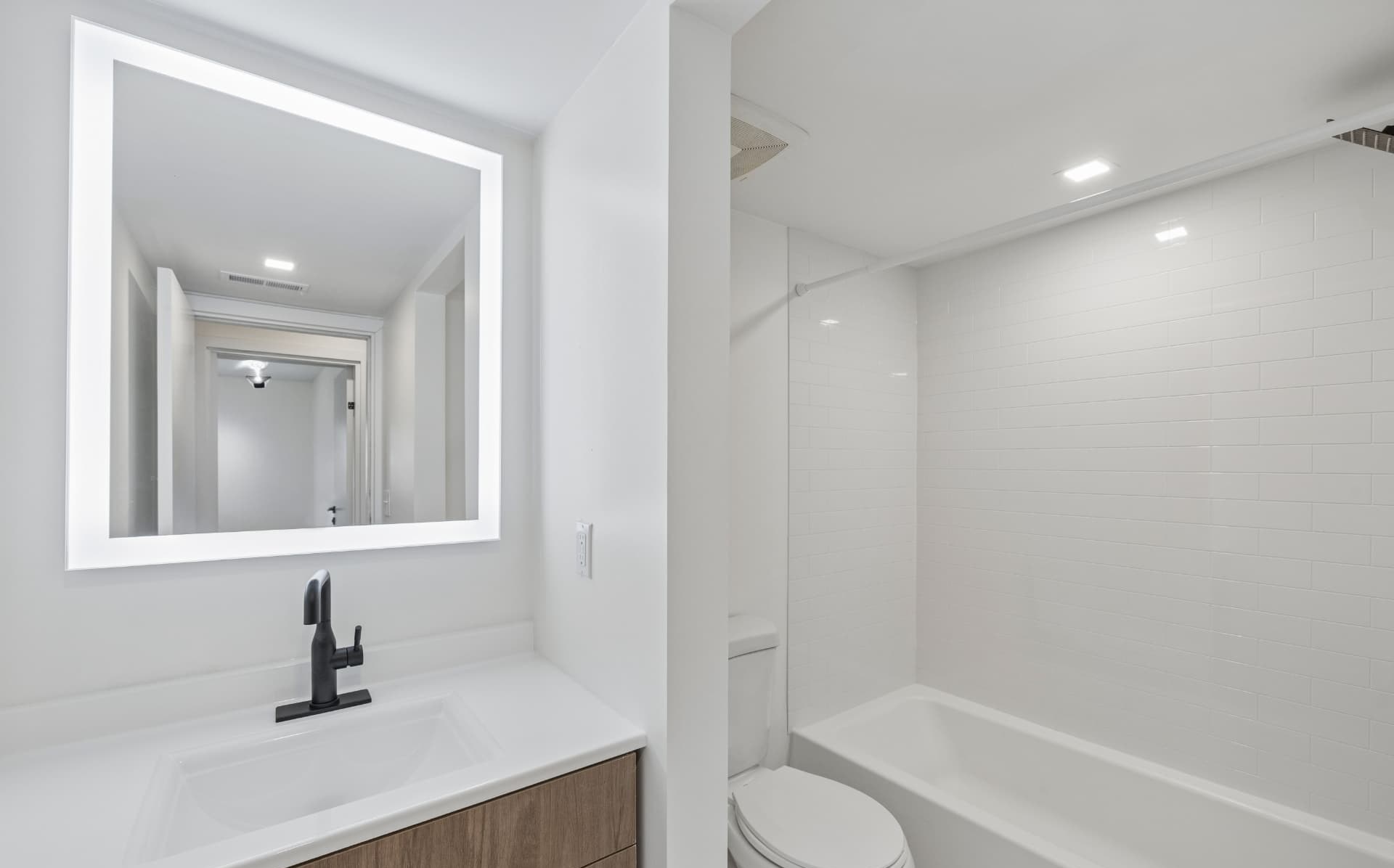 Bathroom with backlit LED mirror and soaking tub